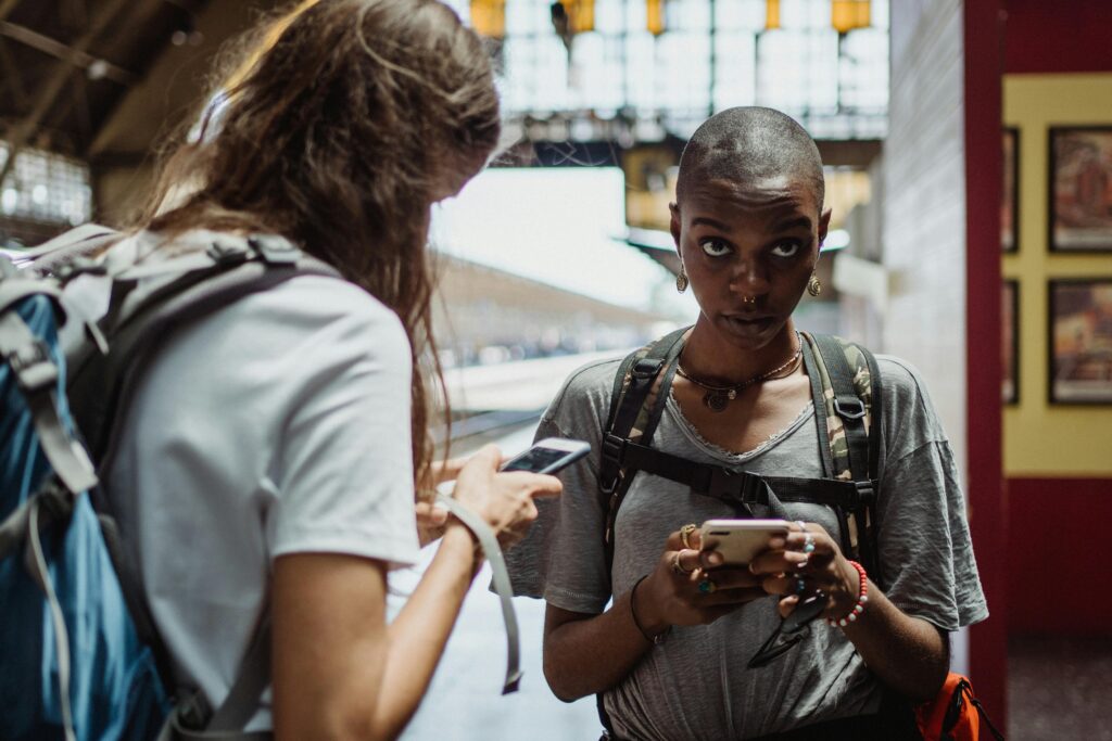 Young women checking Wikipedia in a railway station.